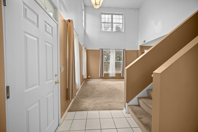 carpeted entryway with a towering ceiling