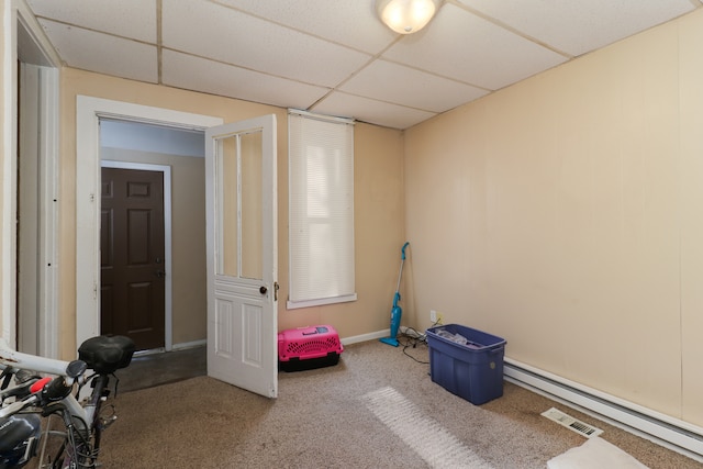 recreation room featuring a baseboard heating unit, a paneled ceiling, and carpet floors