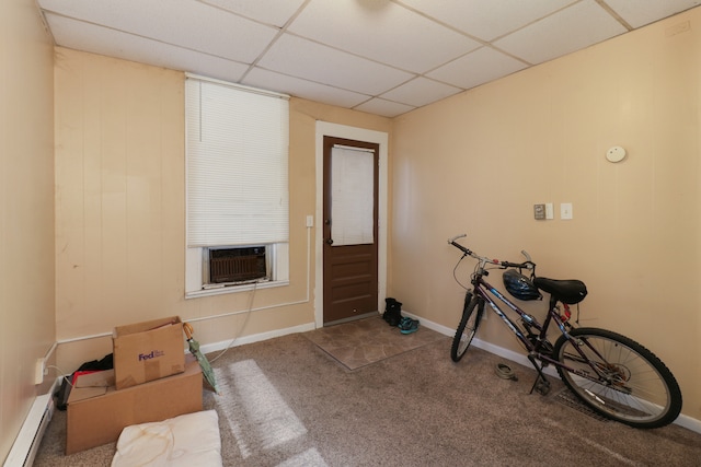 workout area featuring a paneled ceiling, cooling unit, a baseboard heating unit, and carpet floors