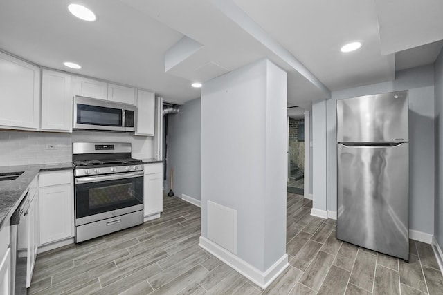 kitchen featuring tasteful backsplash, white cabinetry, and appliances with stainless steel finishes