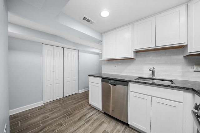 kitchen featuring white cabinets, dishwasher, sink, and dark stone counters