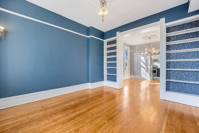 unfurnished room featuring a chandelier and wood-type flooring