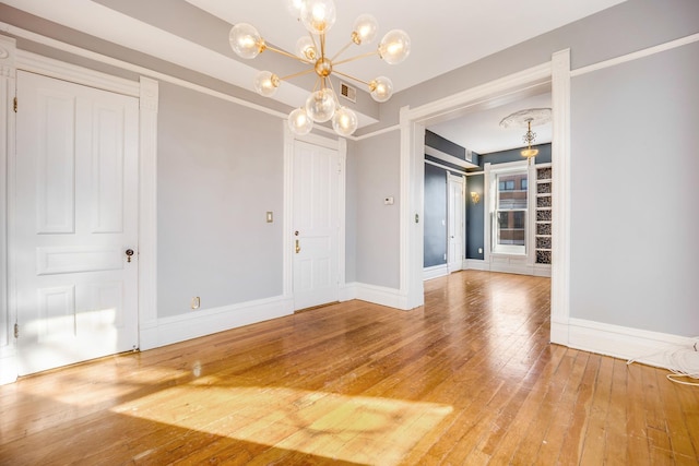 unfurnished dining area featuring hardwood / wood-style floors and a chandelier