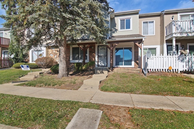 multi unit property featuring a front lawn and a balcony