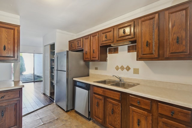 kitchen featuring stainless steel appliances, sink, light wood-type flooring, and crown molding