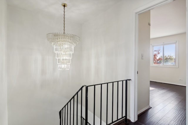 stairway featuring hardwood / wood-style floors and a notable chandelier