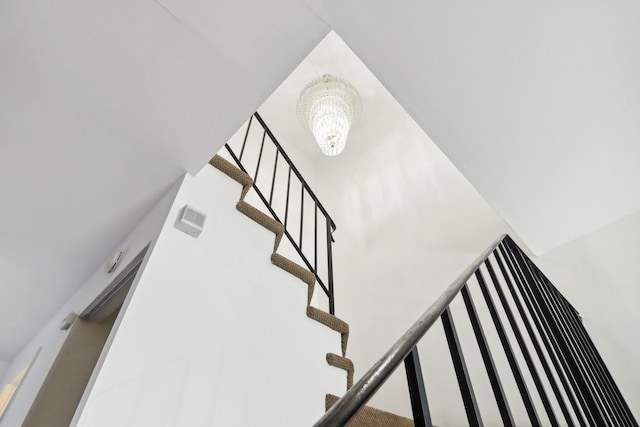 stairs featuring an inviting chandelier