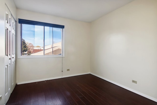 empty room with dark hardwood / wood-style flooring