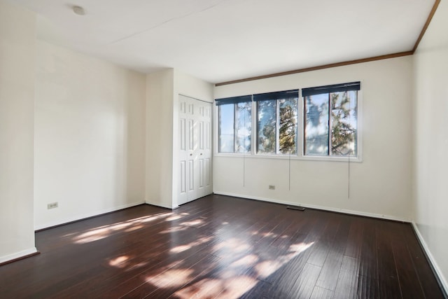 spare room featuring dark hardwood / wood-style flooring and ornamental molding