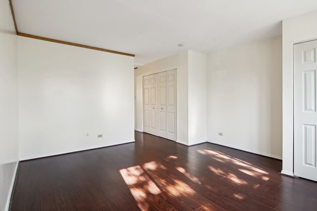 unfurnished room featuring crown molding and dark hardwood / wood-style flooring