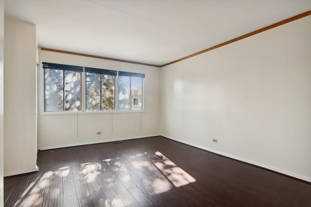 spare room featuring dark wood-type flooring and ornamental molding