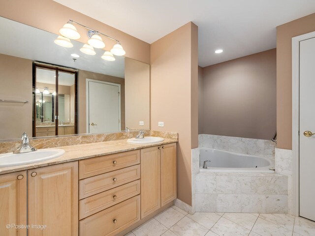 bathroom featuring vanity, tiled bath, and tile patterned floors