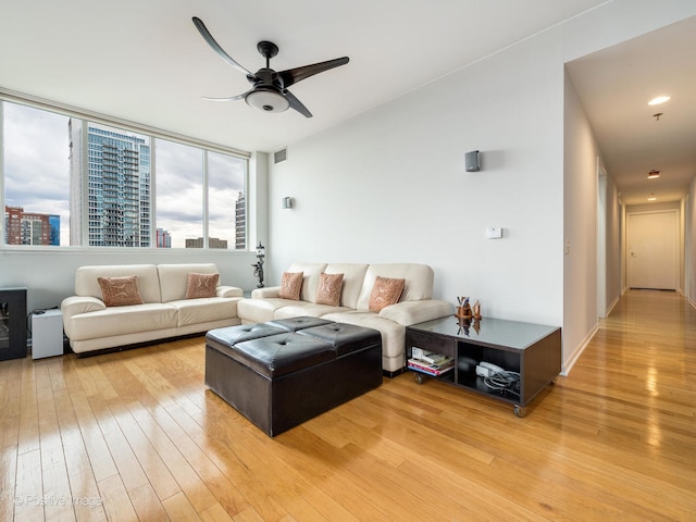 living room with light hardwood / wood-style floors and ceiling fan