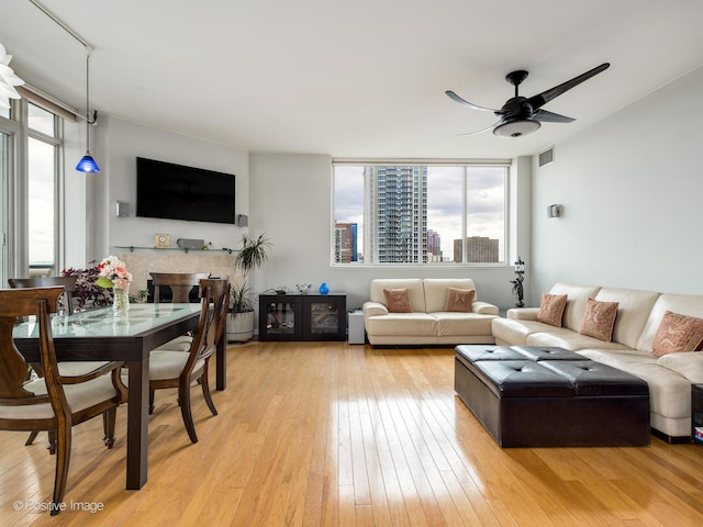 living room featuring ceiling fan and light hardwood / wood-style floors