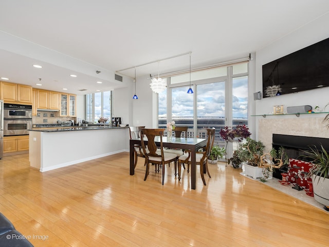 dining area with a premium fireplace and light hardwood / wood-style flooring