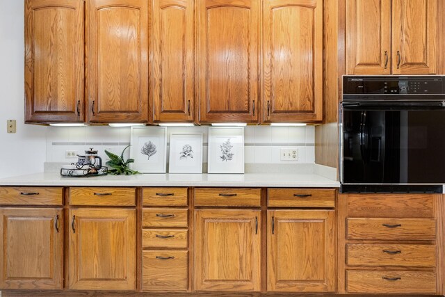 kitchen featuring black oven and decorative backsplash