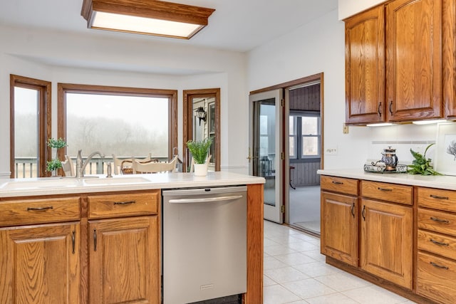 kitchen with stainless steel dishwasher, sink, and light tile patterned floors