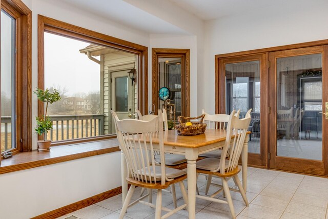 tiled dining space with plenty of natural light and french doors