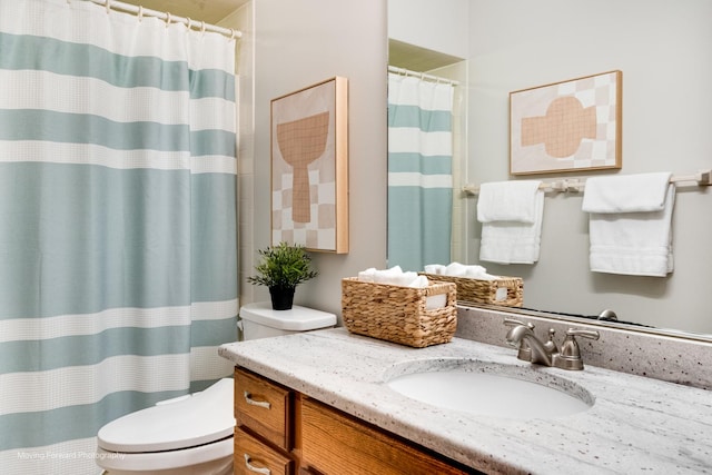 bathroom featuring walk in shower, vanity, and toilet