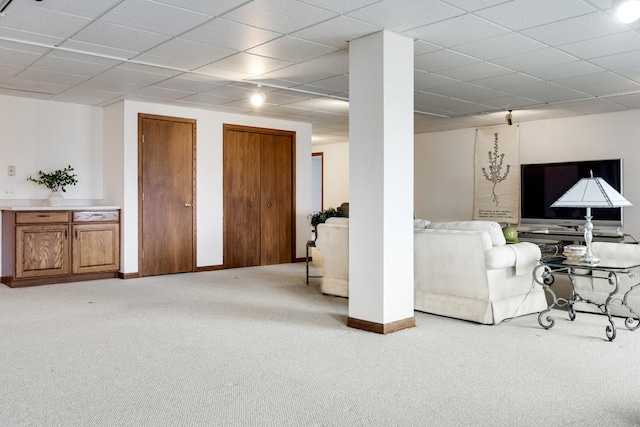 carpeted living room with a drop ceiling