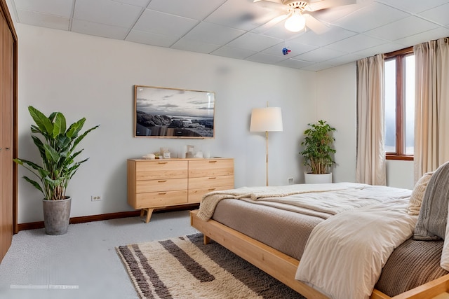 bedroom with a drop ceiling and ceiling fan