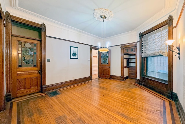 interior space with hardwood / wood-style floors and ornamental molding