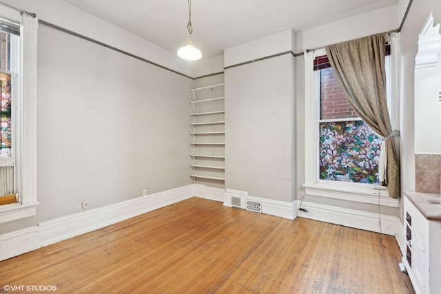 unfurnished room featuring wood-type flooring and a barn door