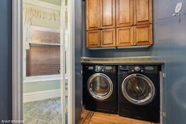 washroom with crown molding, washer and clothes dryer, and cabinets