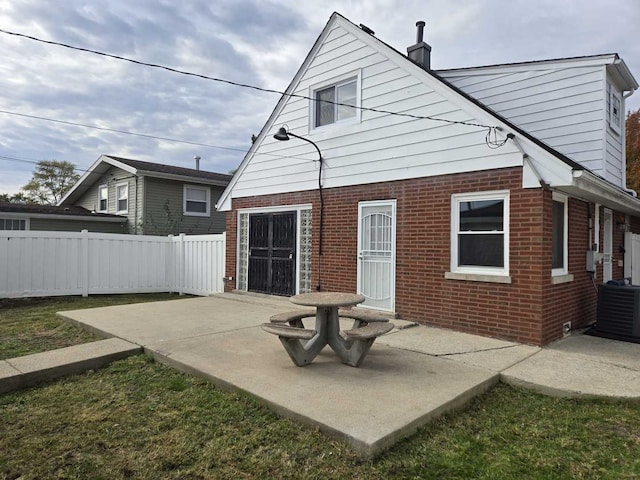 back of property with central AC unit and a patio area