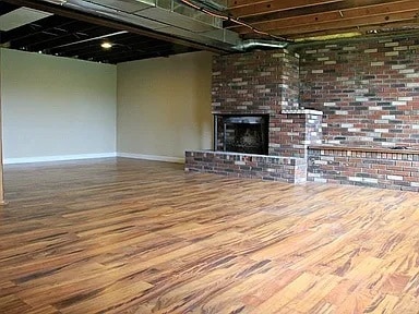 unfurnished living room with a fireplace and wood-type flooring