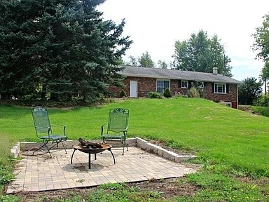 view of yard featuring an outdoor fire pit and a patio