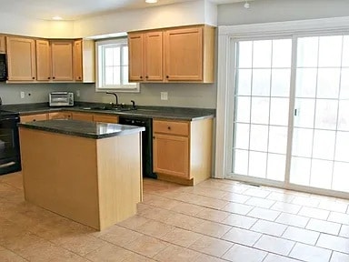 kitchen featuring light tile patterned flooring, plenty of natural light, black appliances, and a center island