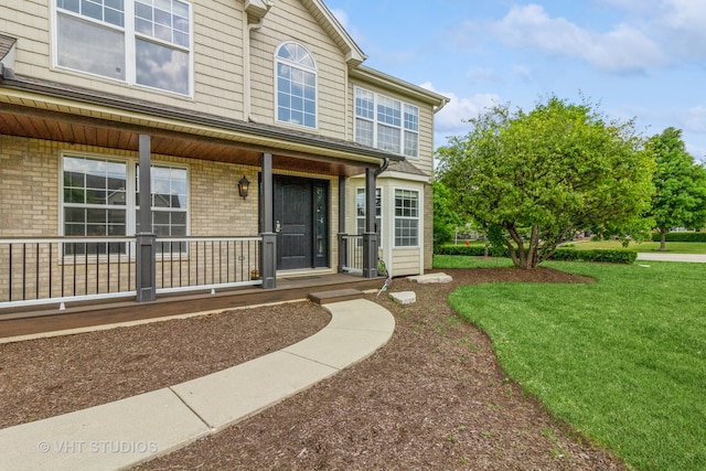 view of front of house featuring covered porch and a front yard