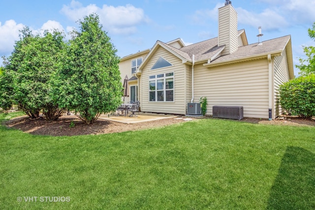 rear view of property featuring a yard, cooling unit, and a patio