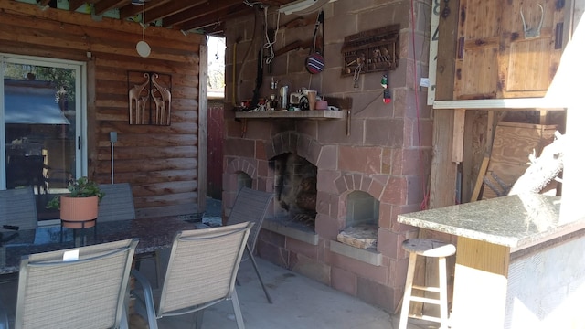 view of patio / terrace with a fireplace and exterior bar