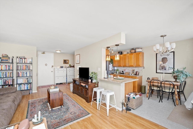 living room with a chandelier and light wood-type flooring