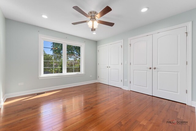 hallway with hardwood / wood-style floors and an inviting chandelier