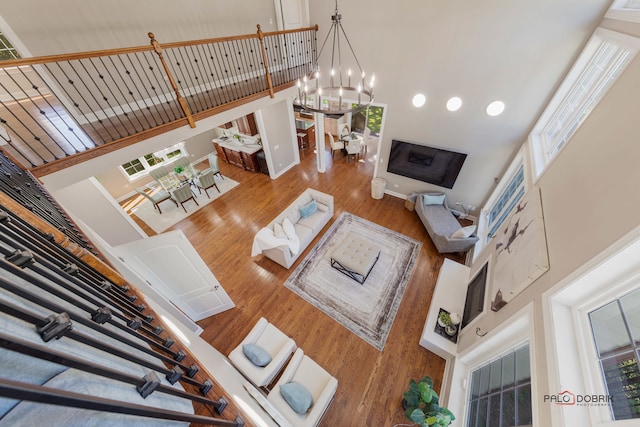 living room with a wealth of natural light, wood-type flooring, and a towering ceiling