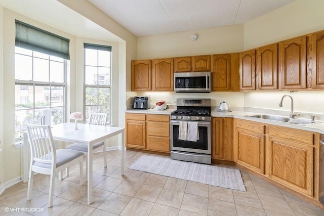 3135 Town Square Dr Unit 106, Rolling Meadows, IL 60008 - kitchen featuring stainless steel appliances, light countertops, light tile patterned floors, and brown cabinetry