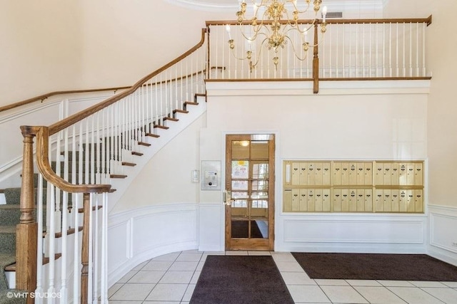 3135 Town Square Dr Unit 106, Rolling Meadows, IL 60008 - staircase featuring a decorative wall, tile patterned flooring, a wainscoted wall, and a chandelier