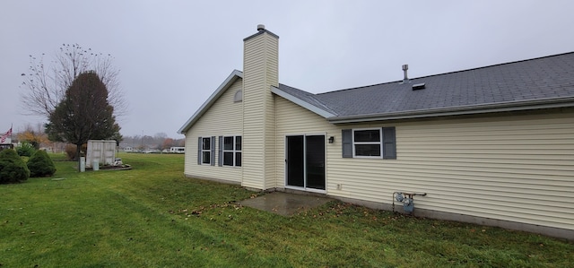 rear view of property featuring a lawn