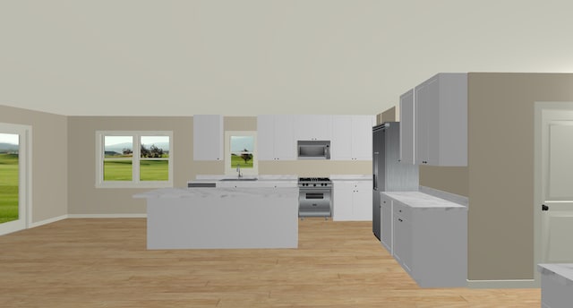 kitchen with sink, high end stainless steel range, white cabinets, and light hardwood / wood-style flooring