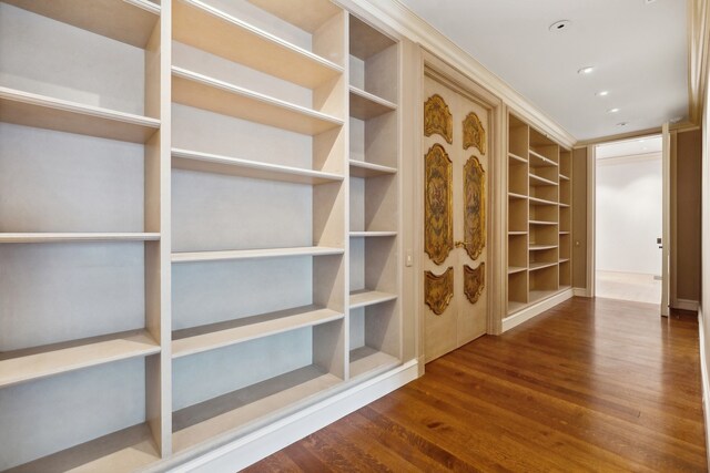 walk in closet with dark hardwood / wood-style floors