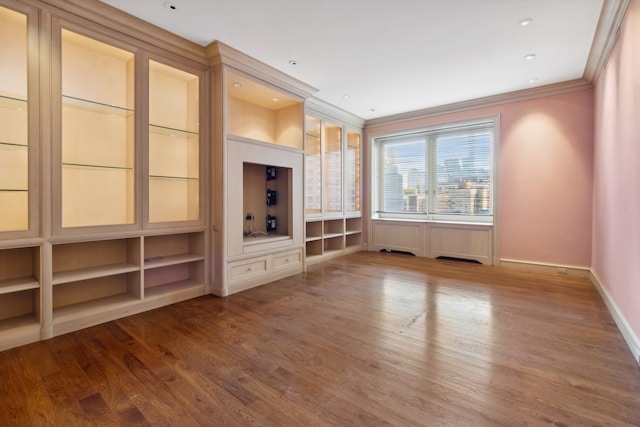 unfurnished living room with hardwood / wood-style floors and ornamental molding