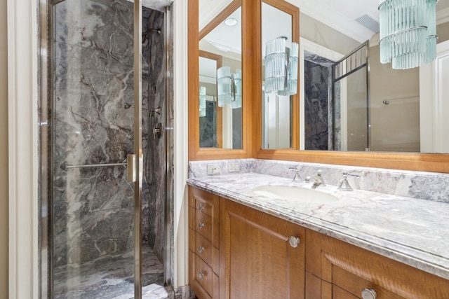 bathroom with a shower with shower door, vanity, and ornamental molding