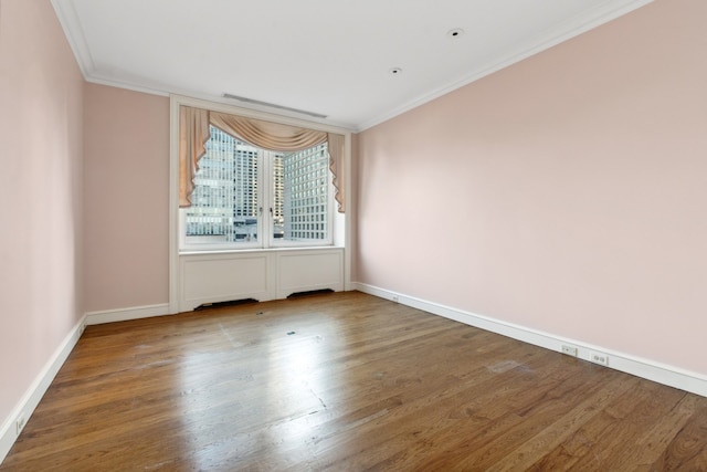 empty room featuring hardwood / wood-style flooring and crown molding