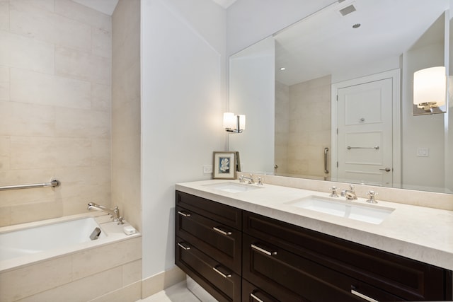 bathroom with vanity and tiled tub