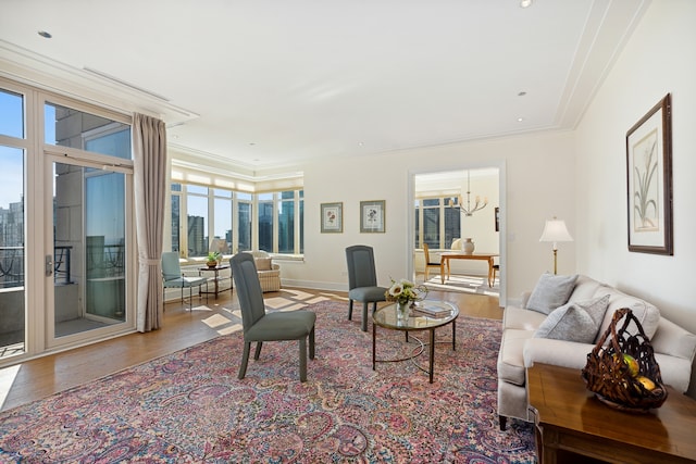 living room featuring ornamental molding, hardwood / wood-style floors, and an inviting chandelier