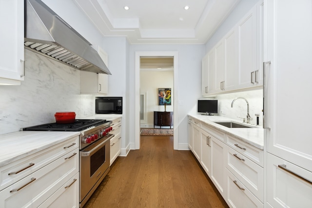 kitchen featuring designer range, sink, white cabinets, dark wood-type flooring, and wall chimney exhaust hood