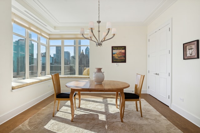 dining space with a wealth of natural light, hardwood / wood-style floors, and ornamental molding